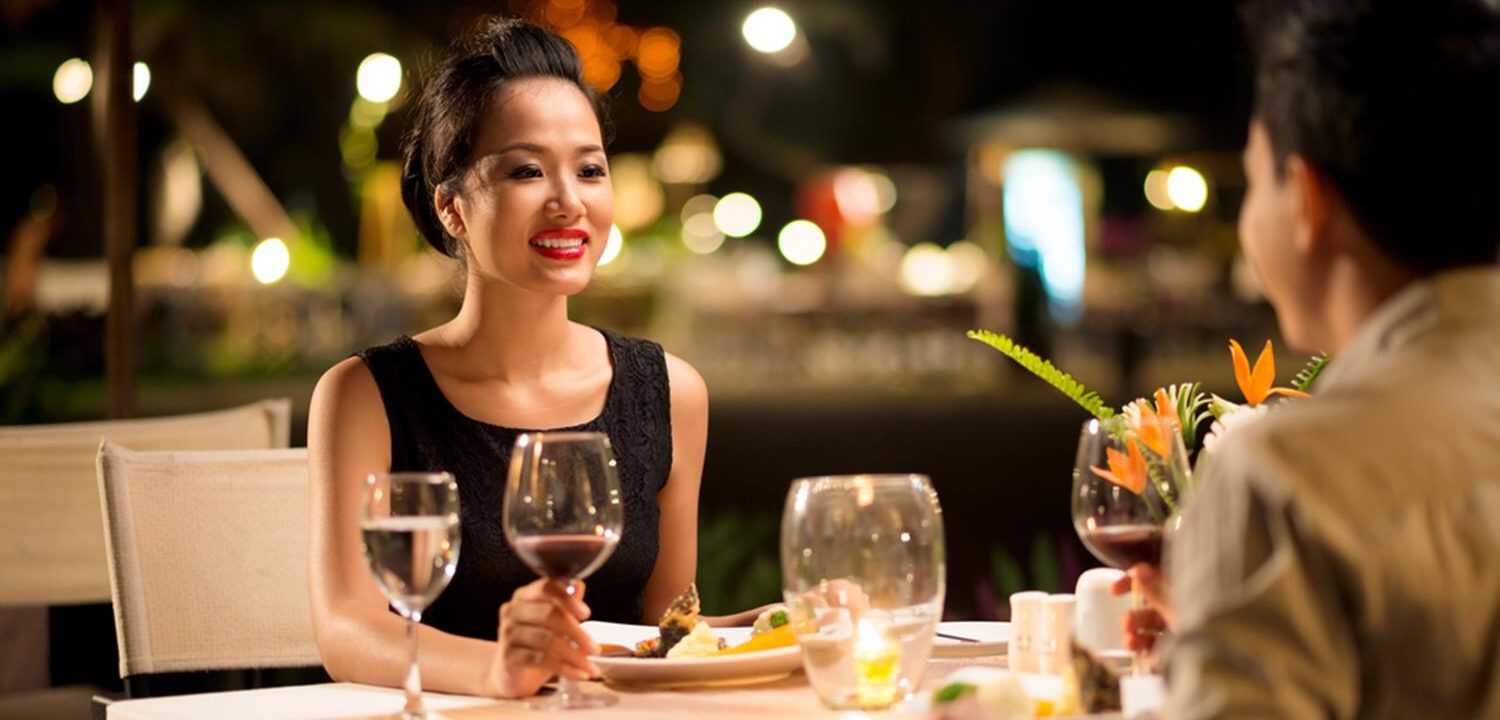A man and woman sitting at a table enjoying a lovely dinner.